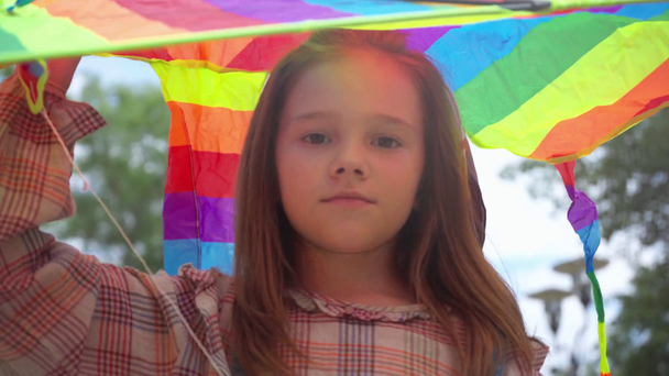 公園で虹凧で歩くかわいい子供 ストック動画映像